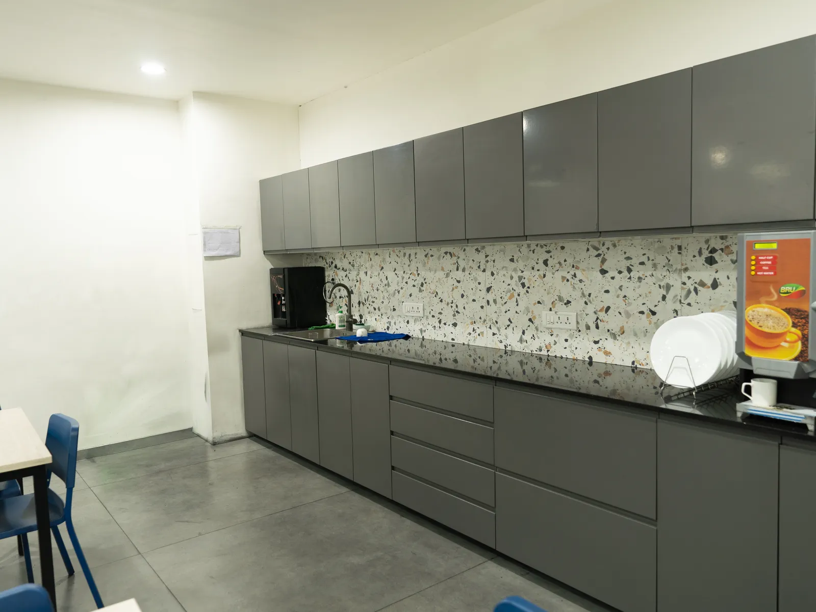 Office pantry with grey cabinets and terrazzo backsplash — LICO